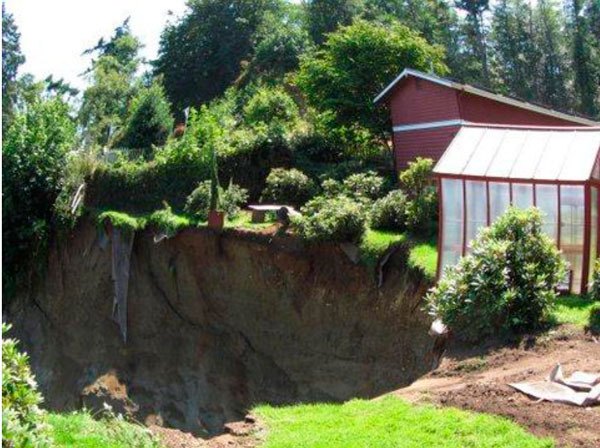 A massive hole now occupies what used to be Langley residents Roy and Rosalie Ballinger’s back yard. They began losing ground about a week ago and have lost up to 90 feet of property. An underground spring may be responsible.