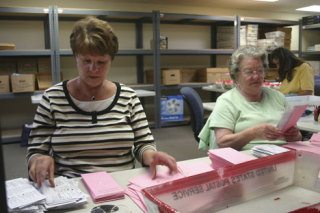 Shawna Davis and Anna Tamura conduct a first review of ballots for the primary election on Wednesday in Coupeville.