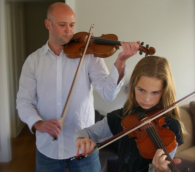 Musician Teo Benson is pictured teaching a violin student. Benson will be performing along with Nola Allen