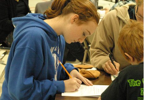 Langley Middle School eighth-grader Maddie Jerome carefully reviews the worksheet used by  secondary students taking an immersive course on bullying last month. The two-day event focused on getting kids to admit a problem exists