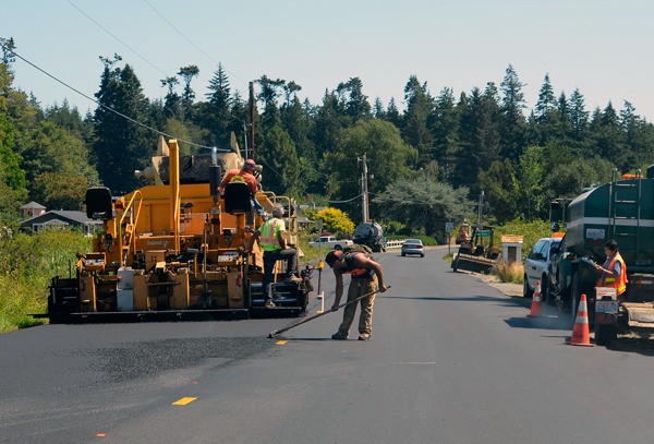 Work crews overlay a section of Mutiny Bay Road on Thursday. The county is in the midst of its annual paving and chip sealing program.