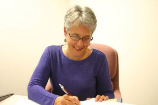 Leigh Anderson signs her first set of documents as a member of the South Whidbey School District board on Wednesday night.