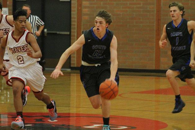 Senior Falcon Chase White dribbles down the court with Coupeville’s Risen Johnson in tow. White finished with 16 points in South Whidbey boys basketball’s 61-30 win over the Wolves on Dec. 2.