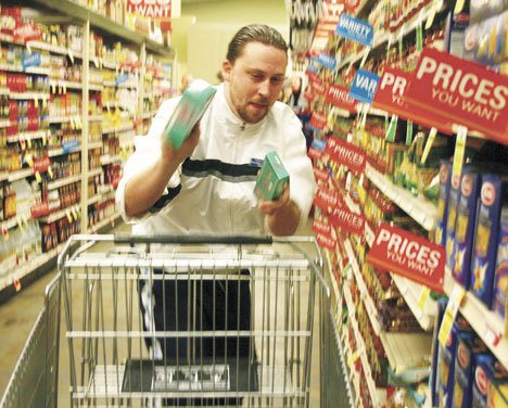 Good Cheer Food Bank manager Damien Cortez hustles through the Goose Community Grocer's aisles on his five-minute shopping spree Friday. Cortez added $3