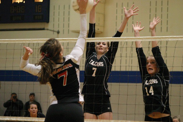 Linden Firethorne and Molly Rawls leap to block Wildcat hitter Sarah Jamieson.