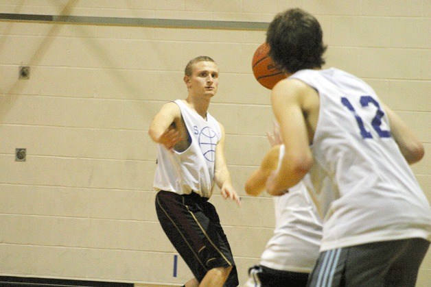 Sam Lee passes to Taylor Simmons as Zach Comfort defends the paint during practice.