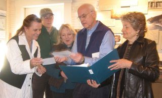 South Whidbey Historical Society President Bob Waterman looks over documents from the campaign to save Saratoga Woods in Langley on Wednesday. With him are Elizabeth Guss of the Whidbey-Camano Land Trust; Cary Peterson and Cynthia Tilkin