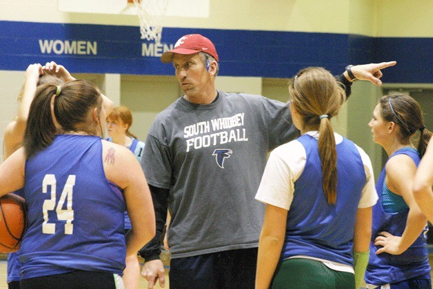 Andy Davis explains a play to the Falcon varsity girls. In his second season