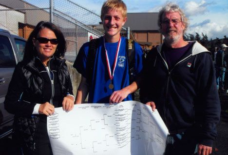 Riley Newman stands with his coaches Sandy McKenzie and Tom Kramer and after winning the 2A District 1 tennis championship in Bellingham on Saturday.