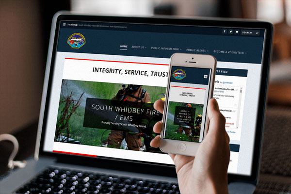 “The new South Whidbey Fire/EMS website is shown on a laptop and mobile device. The new site is mobile-friendly and has new features such as a live Twitter feed and video section. The site’s content will also be constantly updated.