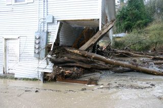 Logs carried by the flash flood damaged homes in the Glendale neighborhood on Friday.