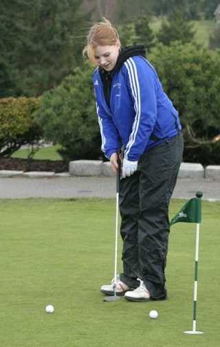 Sarah Muncey-Gordon carefully lines up her final shot on the putting green at Useless Bay Golf Club on Monday. The Falcon line-up is composed of mostly seniors who plan to give Cascade Conference schools a run for their money on the links this year.