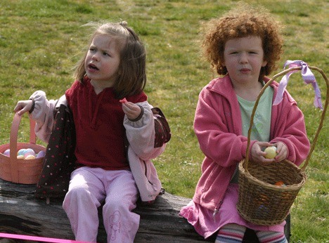 Sisters Araya and Kayla Johnson enjoy the spoils of the hunt after joining a crowd of more than  230 Whidbey kids who filled their baskets with treats at last year’s annual egg hunt. The Easter egg hunt is the next big event at Bayview Community Hall