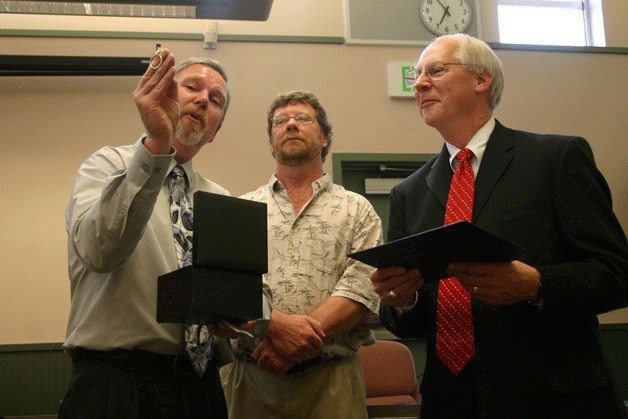 District business and operations director Dan Poolman and Board Chairman Rich Parker present District Superintendent Fred McCarthy with a series of awards and gifts. McCarthy received a certificate of achievement