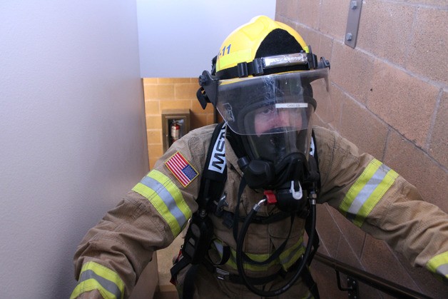 South Whidbey Fire/EMS volunteer Jon Gabelein treks up the steps of the Langley Fire Station to demonstrate the climb he'll do at the Columbia Tower in Seattle in March. He's practicing and raising funds Saturday