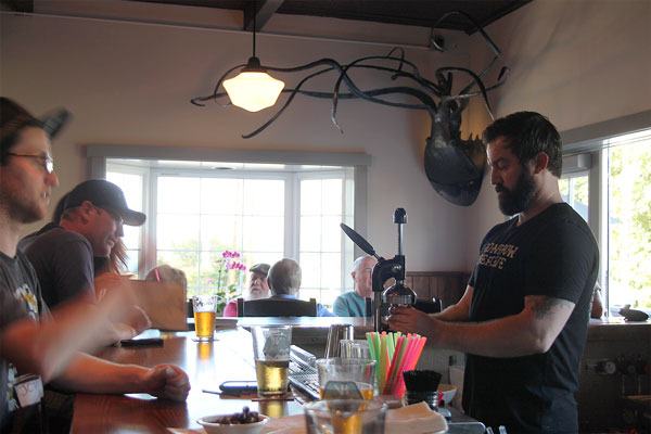 Bartender Ryan Habr squeezes lime juice to concoct a couple of Spyhop’s margaritas as patrons sit at the bar.