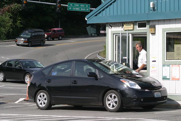 A driver pays for a ticket at the ferry toll both in Clinton Friday. Some daily commuters are fed up with line cutters and have begun to complain to agency officials.