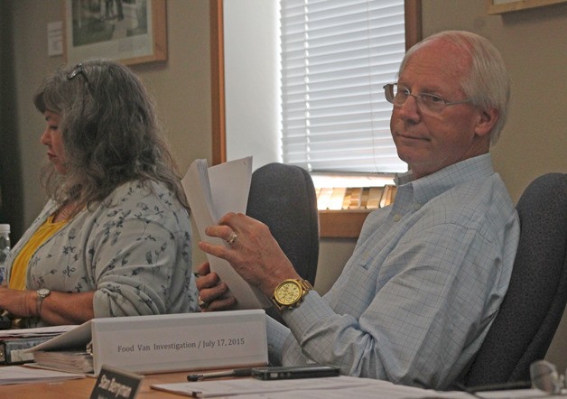 Langley Mayor Fred McCarthy hands out some copies of his investigation executive summary about how a food truck that initially violated the length restriction was approved for its license during the July 20 city council meeting.