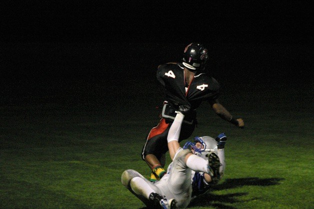 Avery Buechner tackles Wildcat running back Morgan Masanda in the end zone Friday night.