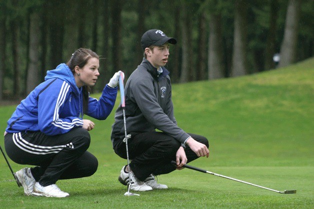 Emily Houck and Shane Thompson examine the putting green on the first hole at Battle Creek Golf Course. The match was South Whidbey golf’s lone jamboree with Kamiak and Lake Stevens high schools.