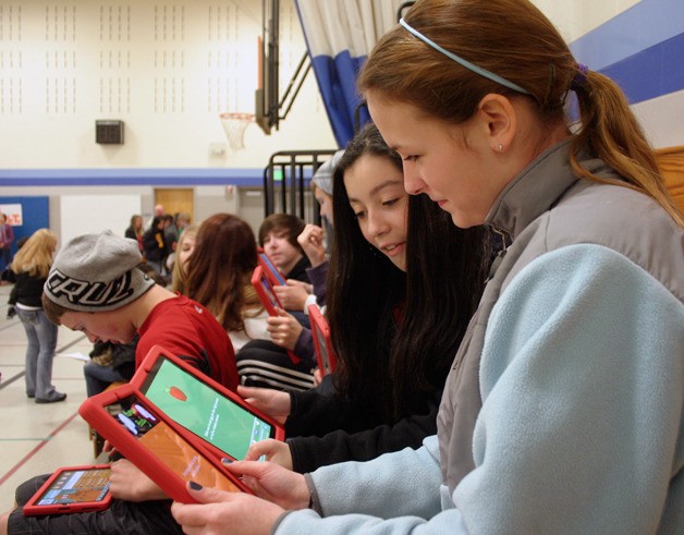 Kayla Gardner and Celeste Hernandez read different health tips from an app on their iPads. Langley Middle School’s seventh-grade students each have a tablet.