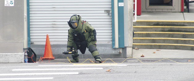 A bomb disposal expert from the Washington State Patrol bomb squad sets up a device to examine a backpack first believed to contain explosives at the Mukilteo Ferry Terminal Thursday morning. A man’s backpack was examined and destroyed by a projected water disruptor.