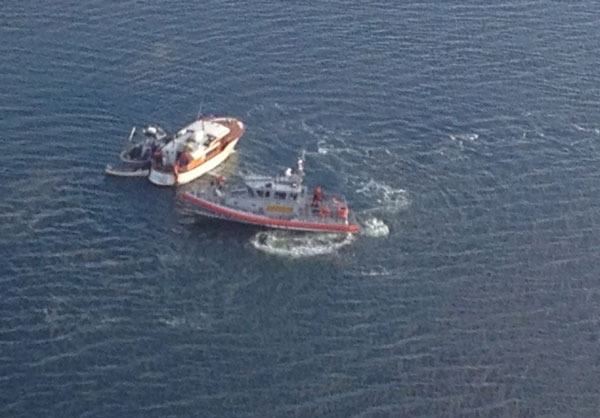 A pleasure boat is assisted by the U.S. Coast Guard.