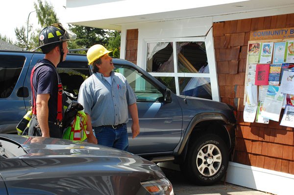 Justin Burnett / The Record Island County Building Official Andy Griffin looks up at Linds Pharmacy in Coupeville after the driver of a SUV accidentally smashed into the business. He has closed that part of the store until repairs can be made.