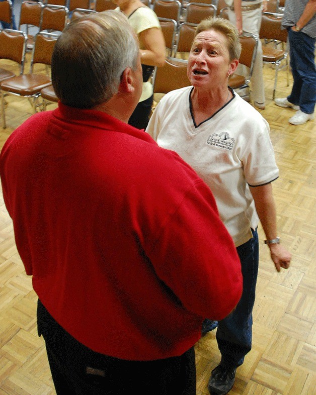 Island County District 2 commissioner candidate Phil Collier gets an earful from Terri Arnold after a primary forum in Oak Harbor on Wednesday.