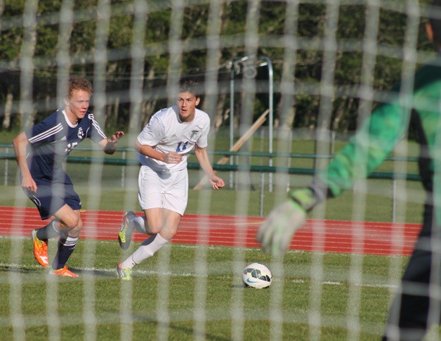 Falcon senior Kai da Rosa looks to cross the ball as he barrels toward the goal with Turk defender Justin Coors in tow. South Whidbey won its final home match against Sultan 3-0 in the 1A District 1 tournament game May 6.