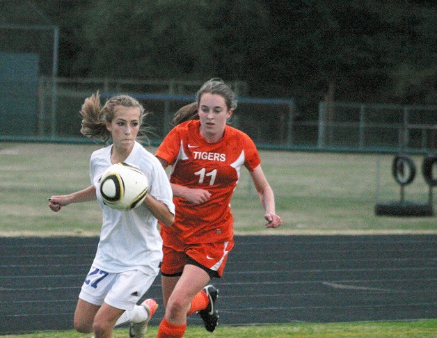 Samantha Baldwin looks toward the Tigers’ goal as senior midfielder Tia Cervarich chases to defend the Falcon freshman on Tuesday.