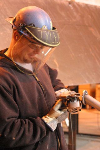 Tyler Reid uses a grinder to put the finishing touches on an  aluminum handrail at Nichols Brothers Boat Builders. Representatives from Nichols have taken part in talks to encourage students to consider paths in the technical trades.