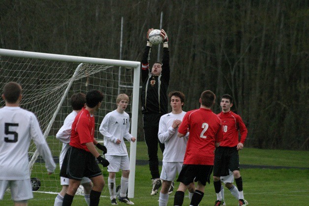 Falcon goalie TJ Russell rises over teammates Connor McCauley (15) and Noah Moeller to block an inbounds throw. Russell stopped more than 20 shots