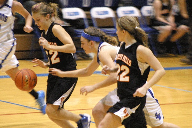 Ellie Greene disrupts a fast break by Tiger guards Jamie Alexander and Peyton Spencer. The Falcon junior led all scorers with 19 points and grabbed 15 rebounds.