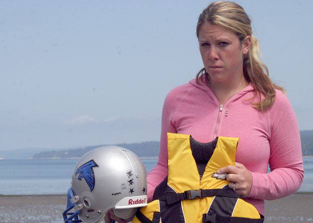 Jacqueline 'JJ' Edwards holds the life jacket and football helmet of her stepson