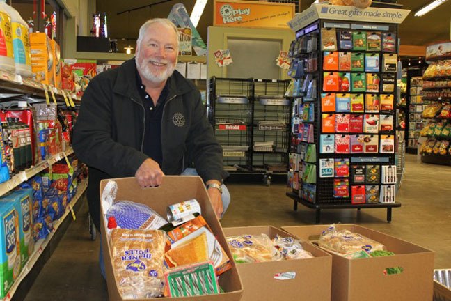 Rotary Club of South Whidbey President Rick Brown assembles food boxes for needy South End families at Goose Community Grocer in Bayview.