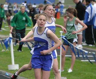 Cassie Bosman passes the baton to sister Courtney on Saturday during the distance medley event at the Westling Invite.