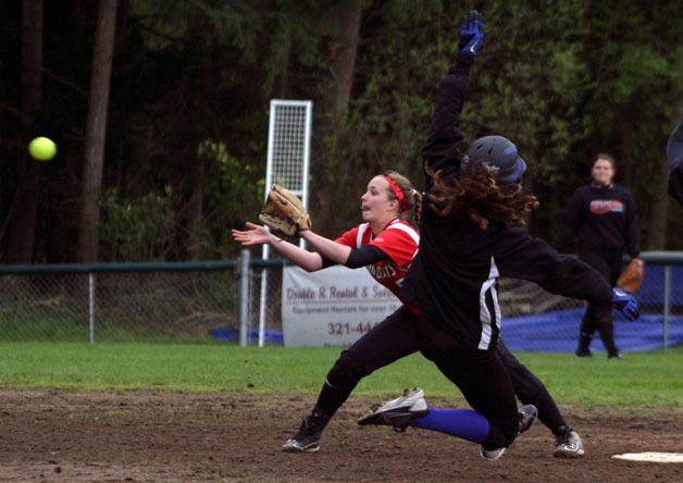 Falcon junior center fielder Ellie Greene leaps before sliding safely into second base under Wildcat shortstop Gemma Miller’s tag.