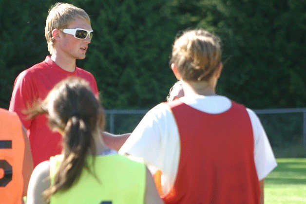 Coach Ben Rusch gathers the girls soccer players for an after practice discussion. In his first year