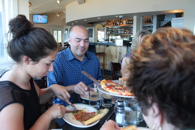 The Portillo family dishes up slices of pizza at Village Pizzeria in Langley on Monday. Pictured are Rosie and her father