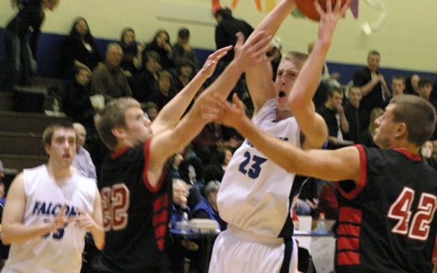 Riley Newman splits two Coupeville defenders for a pull-up jumpshot on Tuesday night. Newman scored a game-high 21 points in South Whidbey’s 44-42 loss to the Coupeville Wolves.