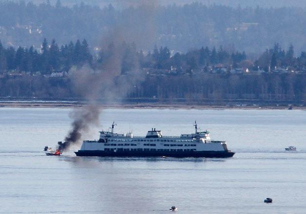 The crew on board the ferry M/V Kittitas helps put out a boat fire near Hat Island on Wednesday.