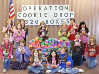 Members of third-grade Brownie Troop 750 gather next to the 320 boxes of cookies they sold for Operation Cookie Drop.