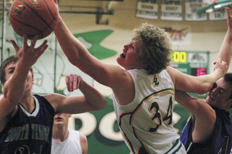 South Whidbey’s Shelby Ball and Tyler “Chuck” Norris battle Ryan Seto of the Lynden Lions for a rebound during Thursday’s playoff game in Mount Vernon.
