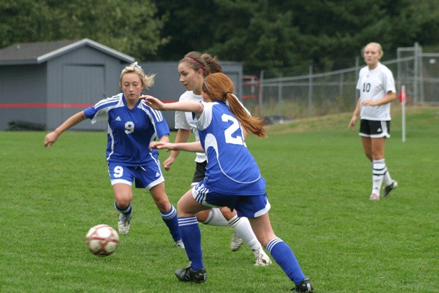 Falcons midfielders Cortney Fredriksen (9) and Maddie Boyd (20) stop Wildcats senior defender Megan Loutsis on Saturday.