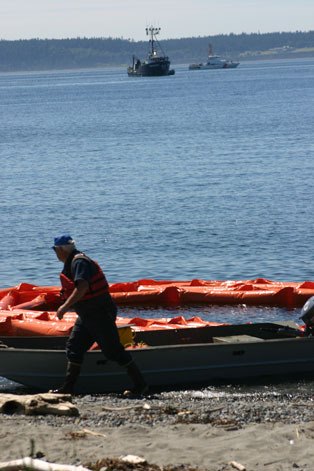 A Global Diving & Salvage worker brings in the floating boom that surrounded the beached Neahkahnie that ran aground early June 4 at Lagoon Point. The rising tide with assist from a tugboat freed the vessel. The Neahkahnie