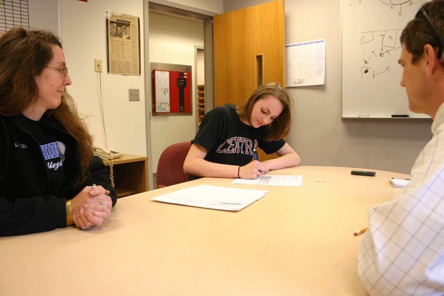 Linden Firethorne signs her letter of intent to play volleyball for Central Washington University with her mom Aristana Firethorne as South Whidbey athletic director Scott Mauk.