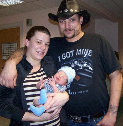 Amanda Everett and Jason Hadnot stand with their new son