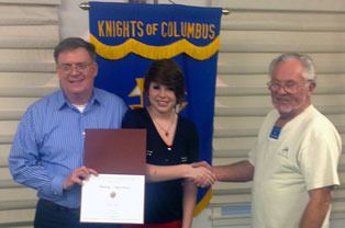 Audrey DiGirolamo shakes hands with Dallas “Tex” Bunney as her father holds the Knights of Columbus