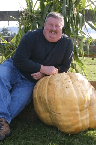 Larry McMaster of Freeland poses with his “ugliest” pumpkin Tuesday. It placed fourth in weight in Coupeville’s annual Giant Pumpkin Contest.